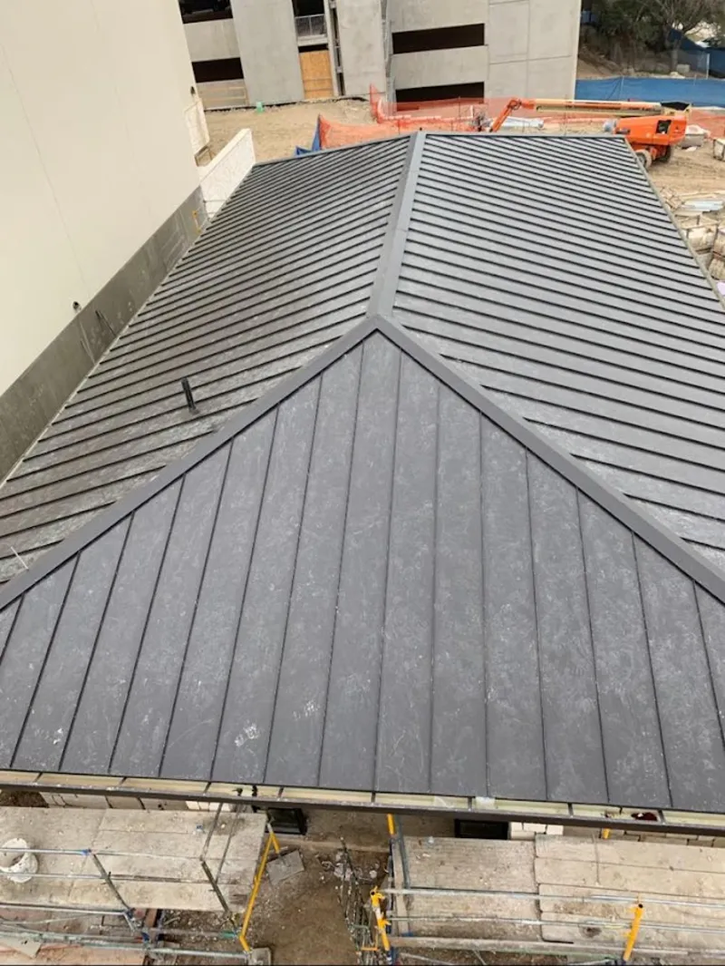 Commercial metal roof construction with crane equipment in Eudora
